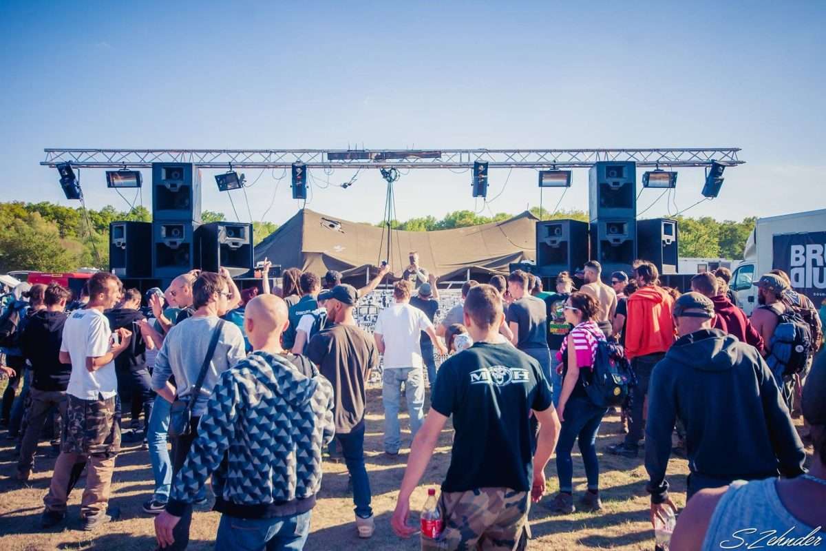 Het geluidssysteem van Bruut Geluid op een festivalterrein, met publiek ervoor